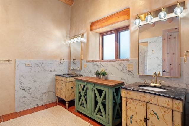 bathroom with tile patterned flooring, vanity, and tile walls