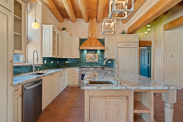 kitchen with appliances with stainless steel finishes, pendant lighting, sink, a kitchen island with sink, and light stone counters