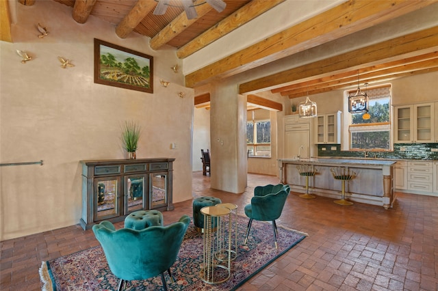 living room featuring a notable chandelier, wood ceiling, sink, and beamed ceiling