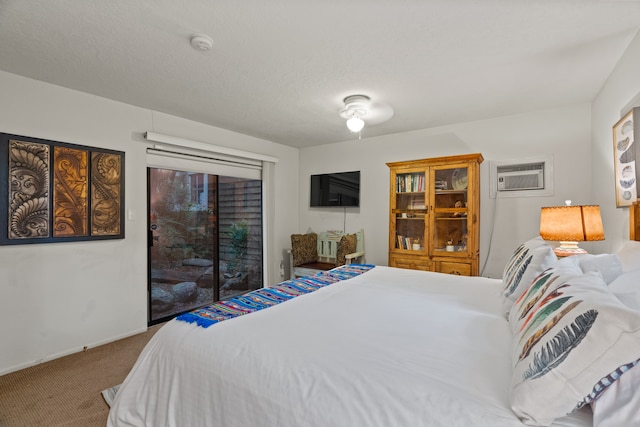 bedroom featuring a wall mounted air conditioner, a textured ceiling, carpet floors, and access to outside