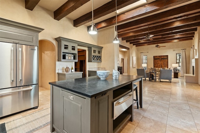 kitchen with beamed ceiling, a center island, stainless steel built in refrigerator, and gray cabinets