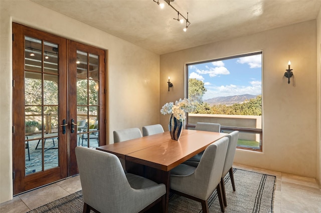 dining space featuring french doors, a mountain view, and light tile patterned floors