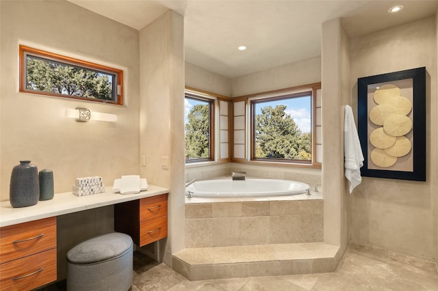 bathroom with vanity, tile patterned floors, and tiled tub