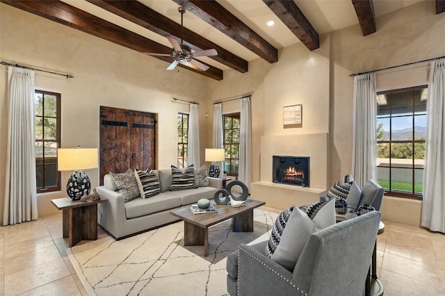 living room featuring beamed ceiling and ceiling fan