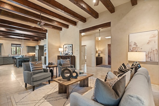 living room featuring beam ceiling, ceiling fan, and light tile patterned floors