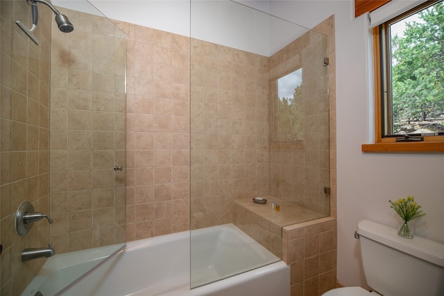 bathroom with toilet, plenty of natural light, and tiled shower / bath