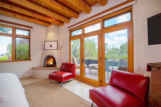 sitting room with beam ceiling, light tile patterned flooring, wood ceiling, and a fireplace