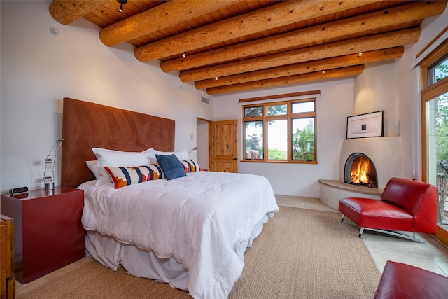 tiled bedroom with wood ceiling, beam ceiling, and a large fireplace