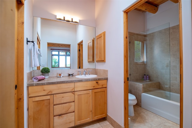 full bathroom featuring toilet, tiled shower / bath combo, vanity, and tile patterned floors