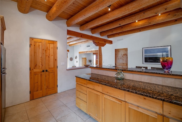 kitchen featuring wood ceiling, dark stone countertops, beam ceiling, and light tile patterned floors