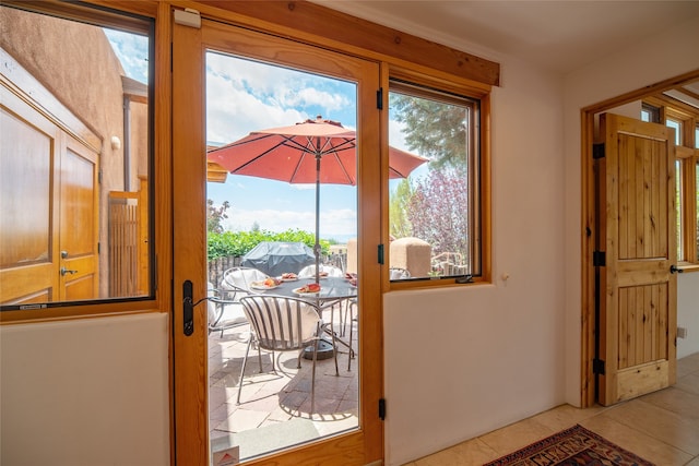 entryway with a healthy amount of sunlight and light tile patterned floors