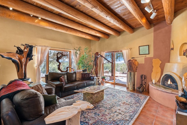 tiled living room with track lighting, wood ceiling, a fireplace, and beamed ceiling