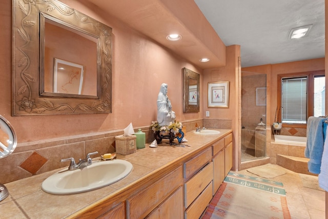 bathroom featuring a sink, tile patterned floors, a shower stall, and double vanity