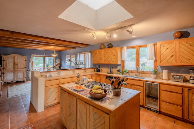 kitchen with sink, wine cooler, beamed ceiling, a kitchen island, and kitchen peninsula