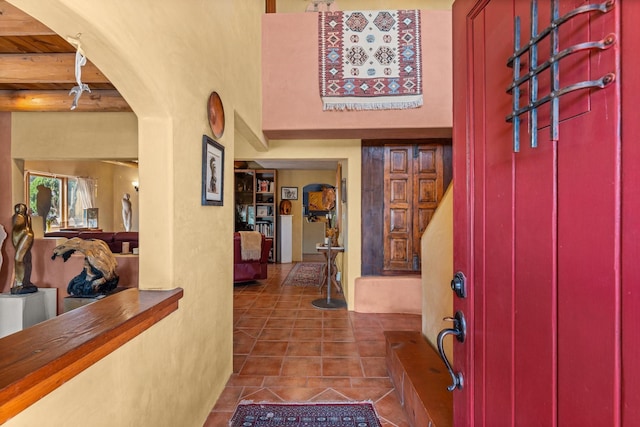entrance foyer with tile patterned flooring and beamed ceiling