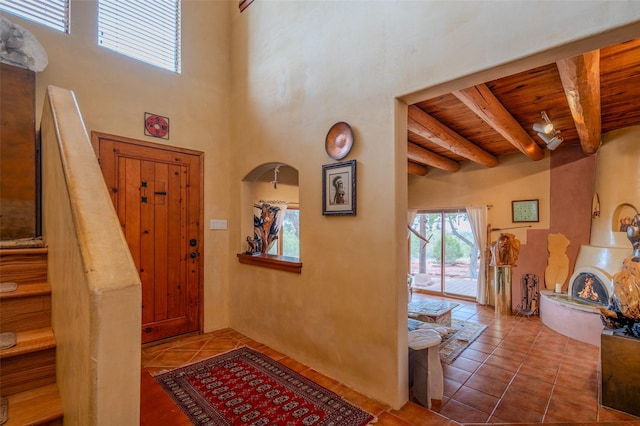 tiled entryway featuring beamed ceiling and wood ceiling