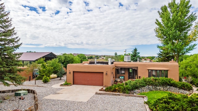 pueblo-style house with a garage