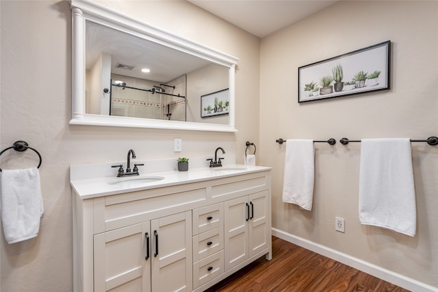 bathroom featuring vanity, wood-type flooring, and walk in shower