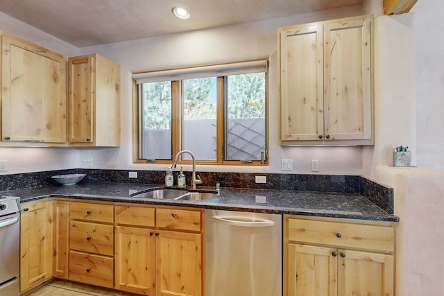 kitchen with light brown cabinetry, dark stone counters, and sink