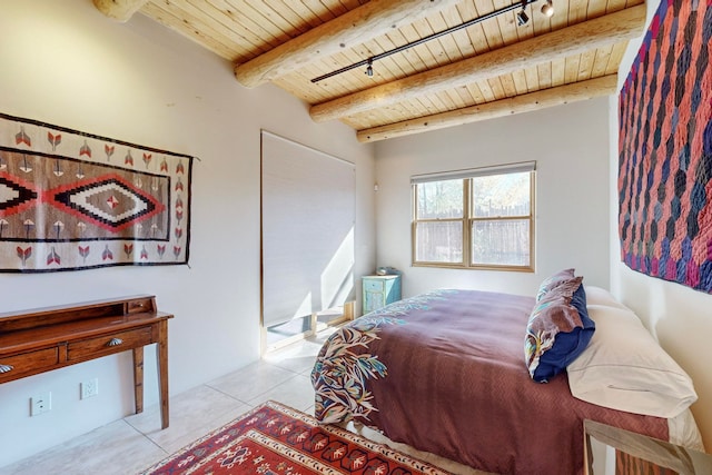 bedroom featuring beam ceiling, light tile patterned floors, and wood ceiling