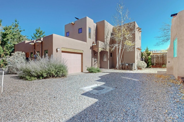 pueblo revival-style home featuring a garage