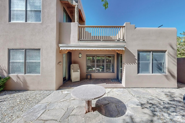 rear view of house with a balcony and a patio