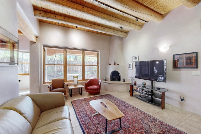 tiled living room with beamed ceiling, a fireplace, and wood ceiling