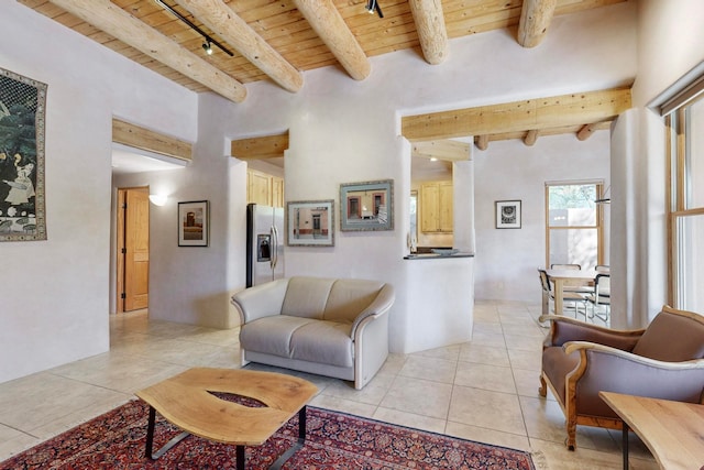 living room with beam ceiling, wooden ceiling, light tile patterned floors, and track lighting