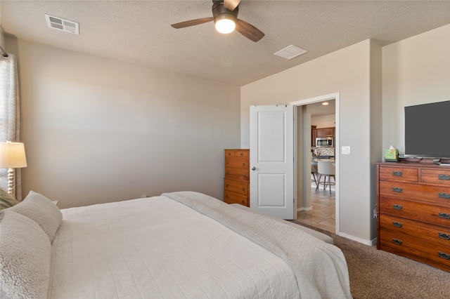 carpeted bedroom with a textured ceiling and ceiling fan