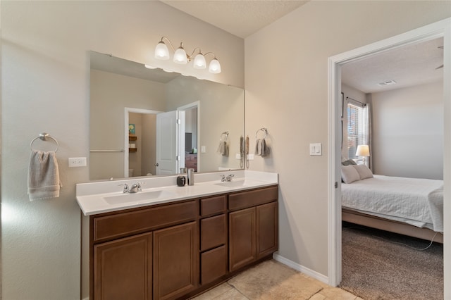 bathroom with vanity, a textured ceiling, and tile patterned flooring