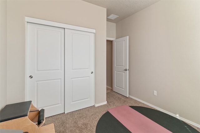 carpeted bedroom featuring a closet and a textured ceiling