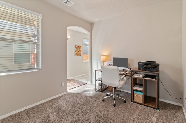 office with a textured ceiling and carpet flooring