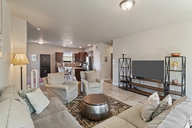 tiled living room featuring a textured ceiling