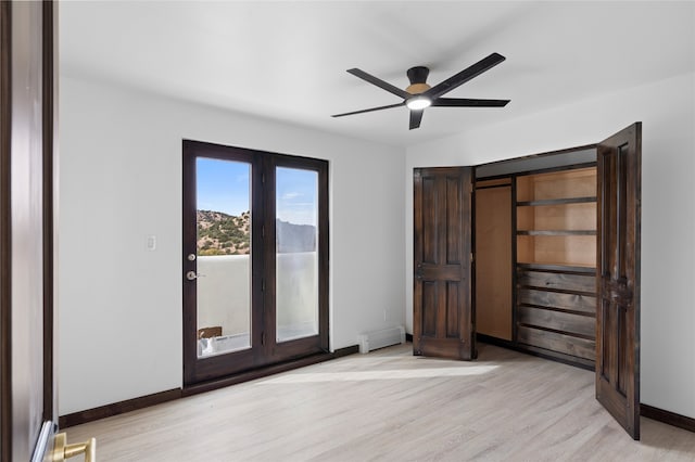 unfurnished bedroom with ceiling fan, baseboard heating, light hardwood / wood-style floors, and access to exterior