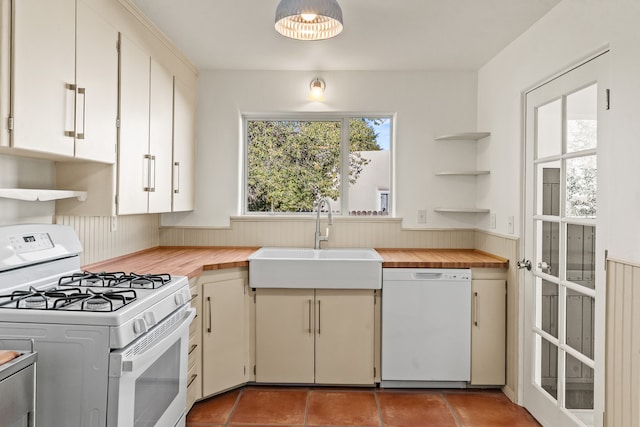 kitchen with sink, wooden counters, and white appliances