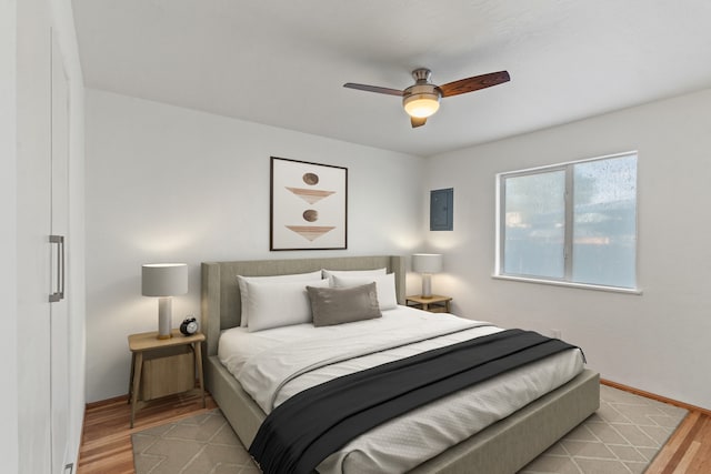 bedroom with electric panel, ceiling fan, and light hardwood / wood-style floors