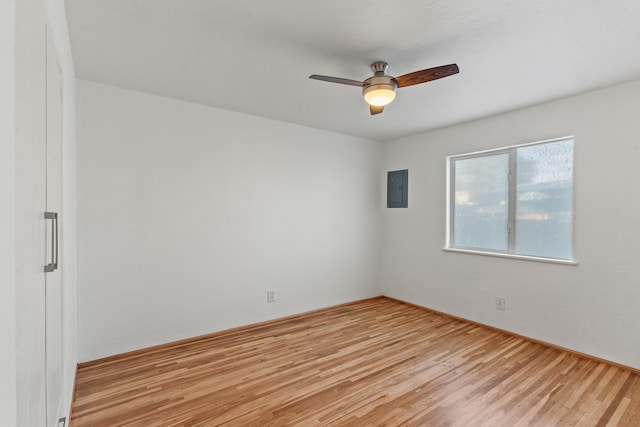 unfurnished room with ceiling fan, light hardwood / wood-style floors, and electric panel