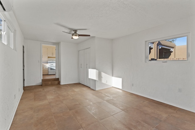 unfurnished bedroom with ceiling fan, light tile patterned floors, a textured ceiling, and a closet