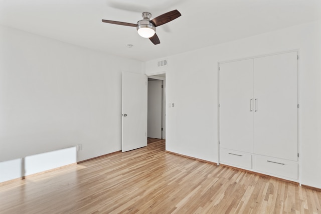 unfurnished bedroom with a closet, light hardwood / wood-style flooring, and ceiling fan