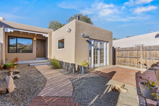 property entrance featuring a patio and french doors