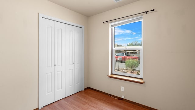 unfurnished bedroom featuring a closet and light hardwood / wood-style flooring