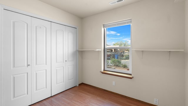 unfurnished bedroom featuring a closet and light hardwood / wood-style flooring