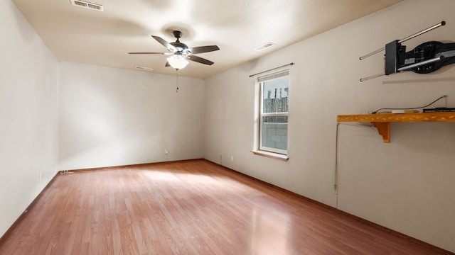 spare room with light wood-type flooring and ceiling fan