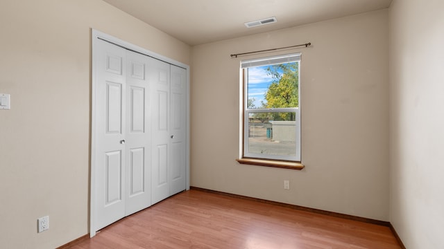 unfurnished bedroom featuring a closet and light hardwood / wood-style flooring