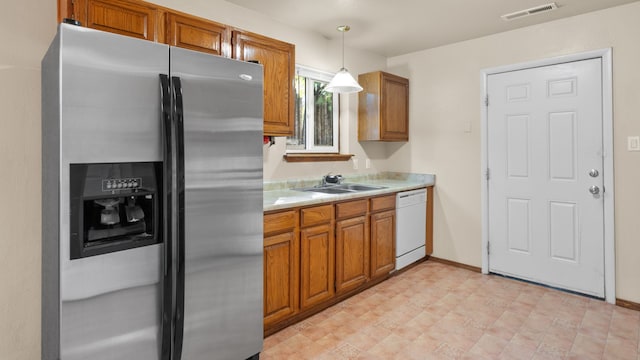 kitchen with dishwasher, stainless steel fridge, decorative light fixtures, and sink