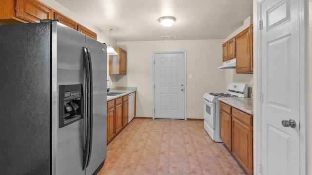 kitchen with white appliances, decorative light fixtures, and sink