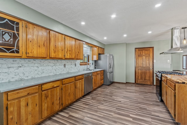 kitchen with ventilation hood, sink, a textured ceiling, appliances with stainless steel finishes, and tasteful backsplash