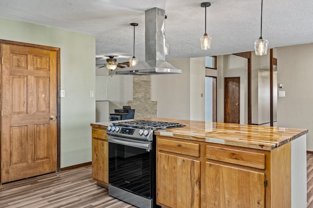 kitchen featuring island exhaust hood, a textured ceiling, stainless steel range with gas cooktop, and hanging light fixtures