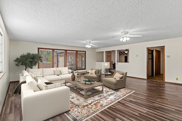 living room with a textured ceiling, ceiling fan, and dark wood-type flooring