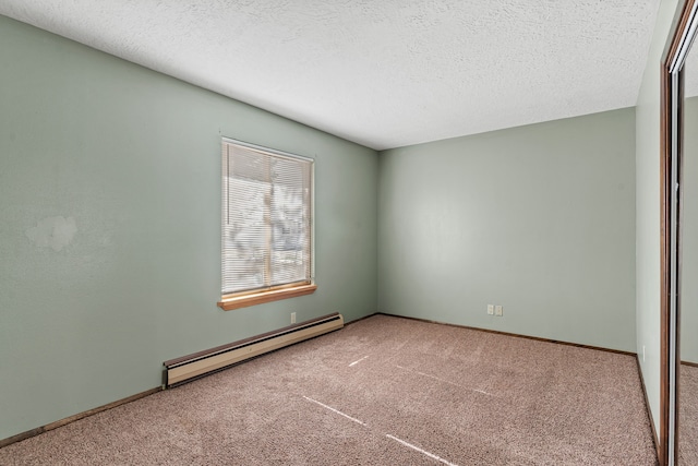 spare room with baseboard heating, carpet floors, and a textured ceiling